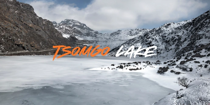 Tsomgo Lake in Sikkim covered with snow and frozen water surrounded by mountains in winter